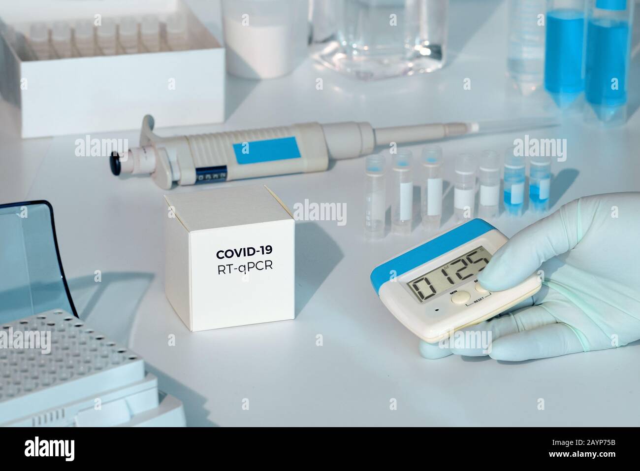 Quick novel COVID-19 coronavirus test kit. 2019 nCoV pcr diagnostics kit. Hand in glove with timer. RT-PCR kit to detect covid19 virus in clinical sam Stock Photo
