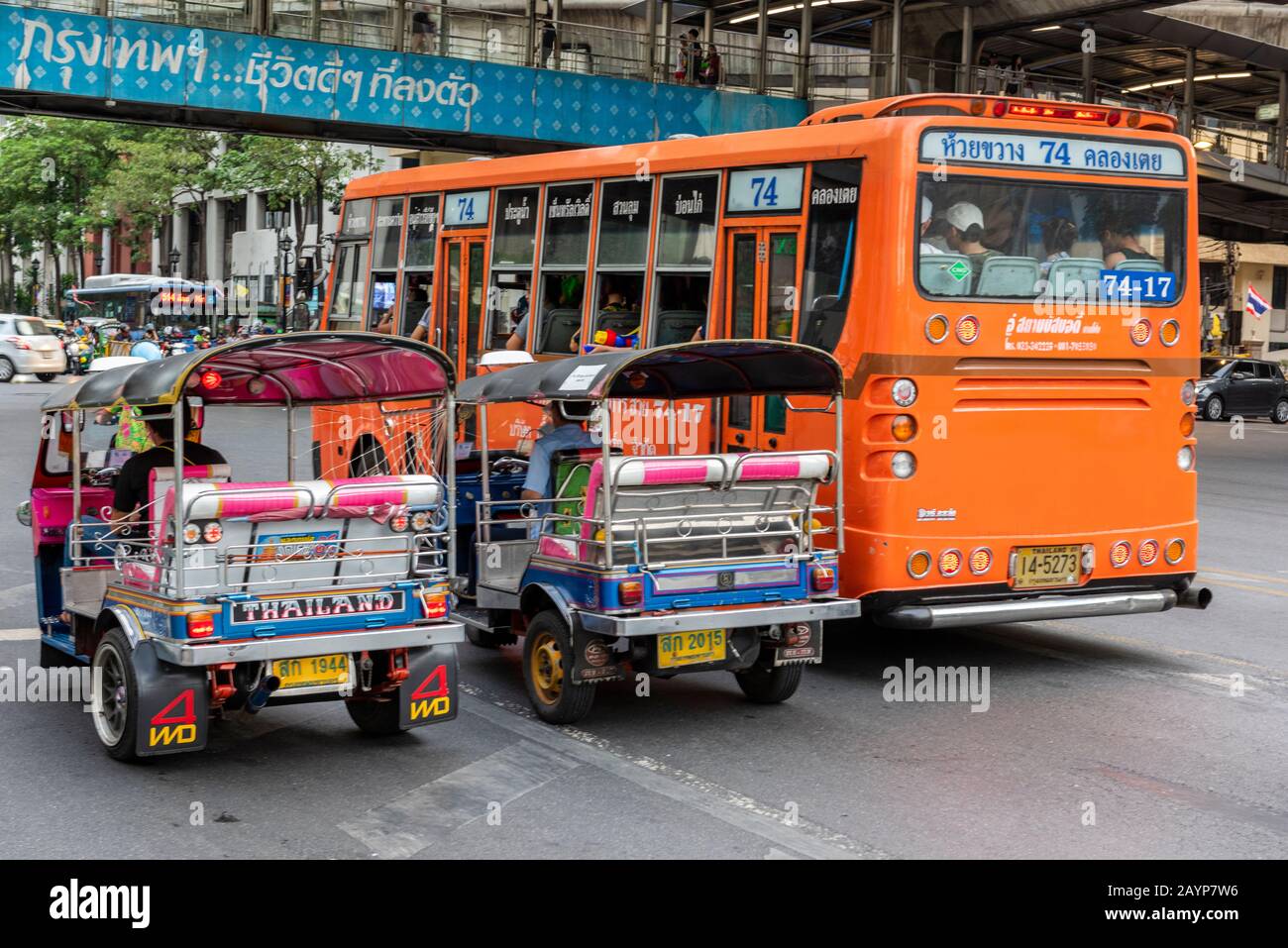 tuk tuk and taxi cabs with busses and public transport in bangkok, thailand on the busy city centre streets at rush hour. Stock Photo