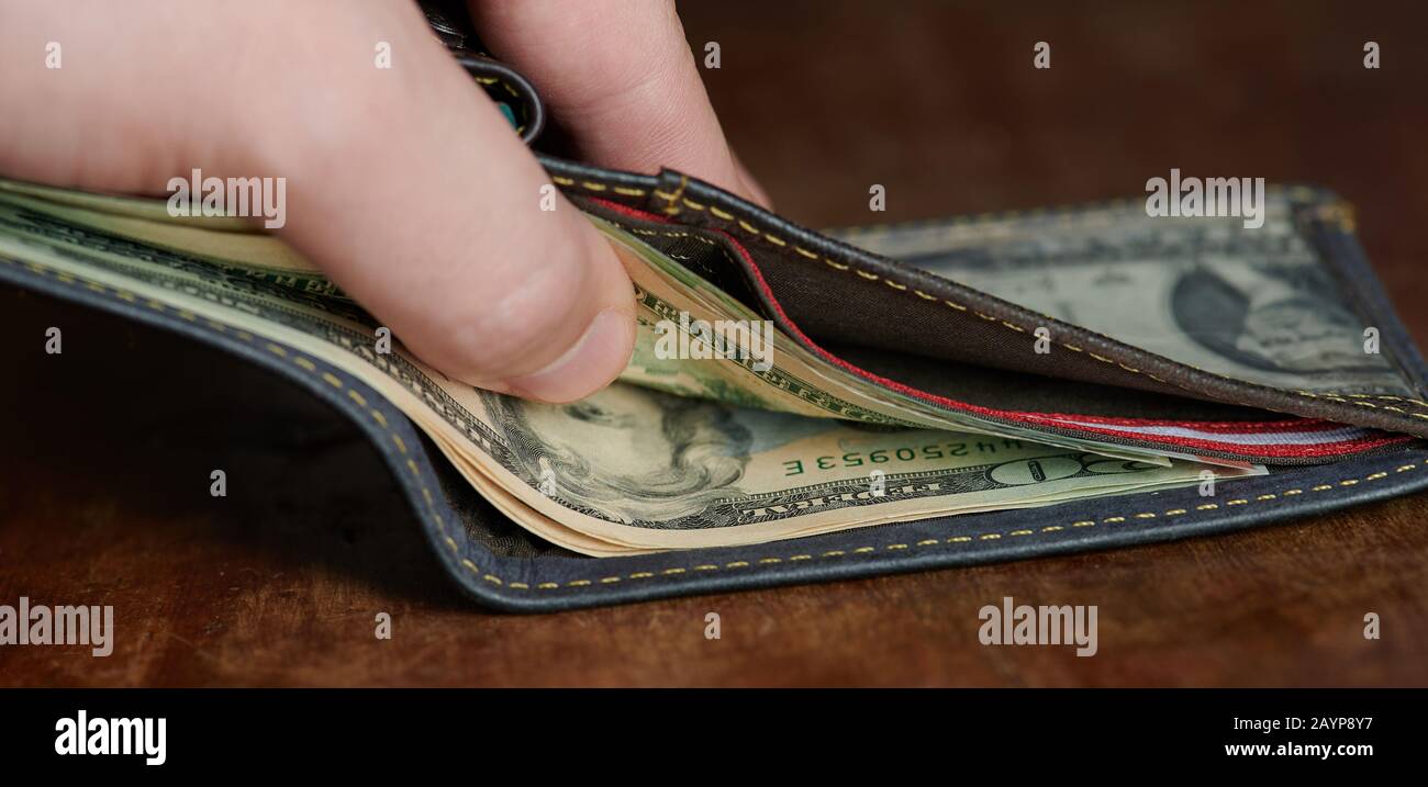 Group of twenty dollars in wallet on wooden desk close up view Stock