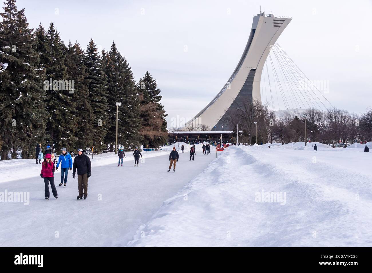 Montreal, CA - 15 February 2020: People  ice skating at the Park Maisonneuve ice rink with olympic Stadium Tower in background. Stock Photo