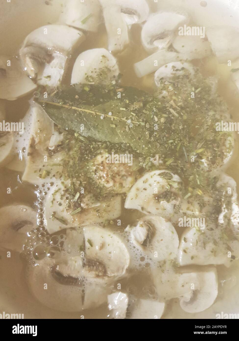 sliced champignons boiled in boiling water with bay leaf and herbs
