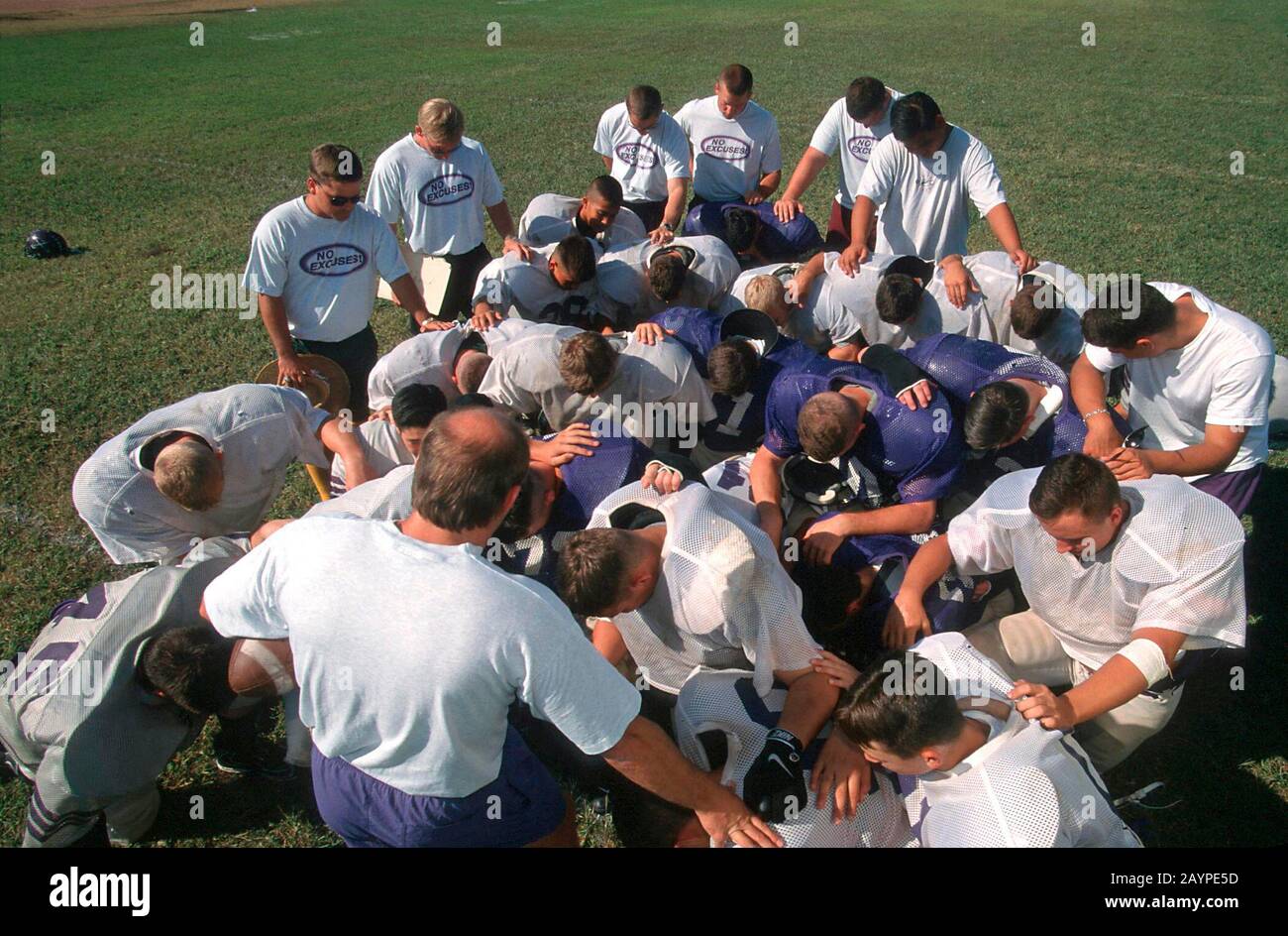 San Marcos, TX: Football team at private Baptist high school prays before practice. ©Bob Daemmrich Stock Photo