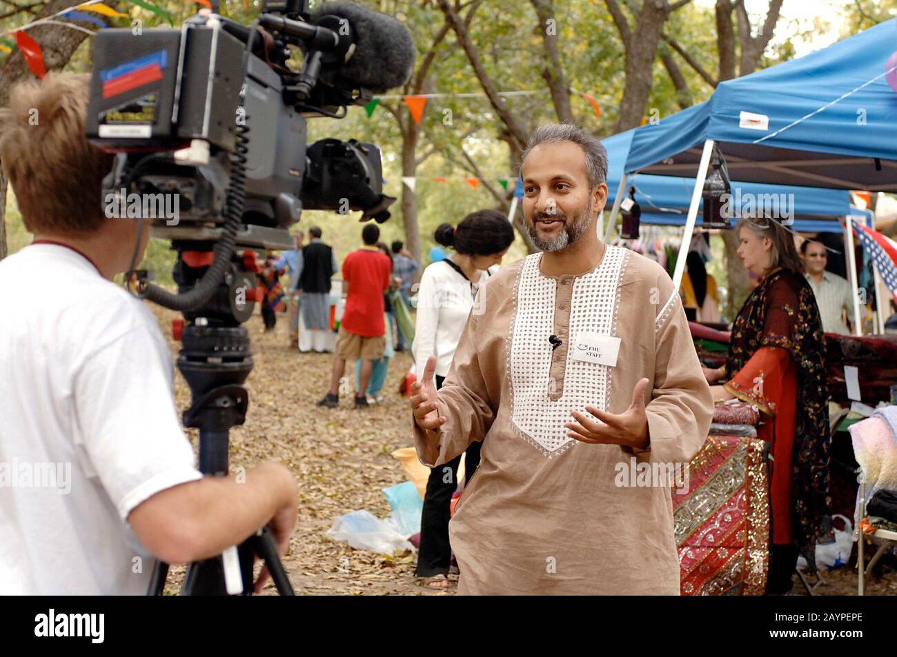 Austin, Texas: November 12, 2005: Muslim organizer of a local End of Ramadan (Eid) festival speaks to local television reporter at the event. The Muslim community of central Texas welcomed all faiths to the gathering showcasing food, dancing and festivities of the Muslim world, sponsored by the Forum of Muslims for Unity (FMU) of central Texas. ©Bob Daemmrich Stock Photo