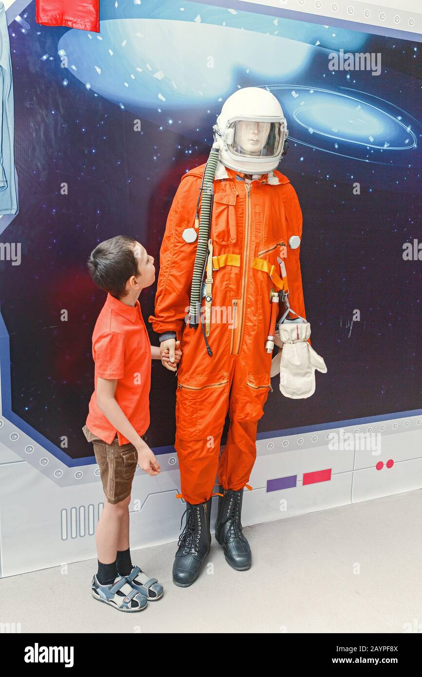 boy looking at astronaut suit costume at educational museum Stock Photo