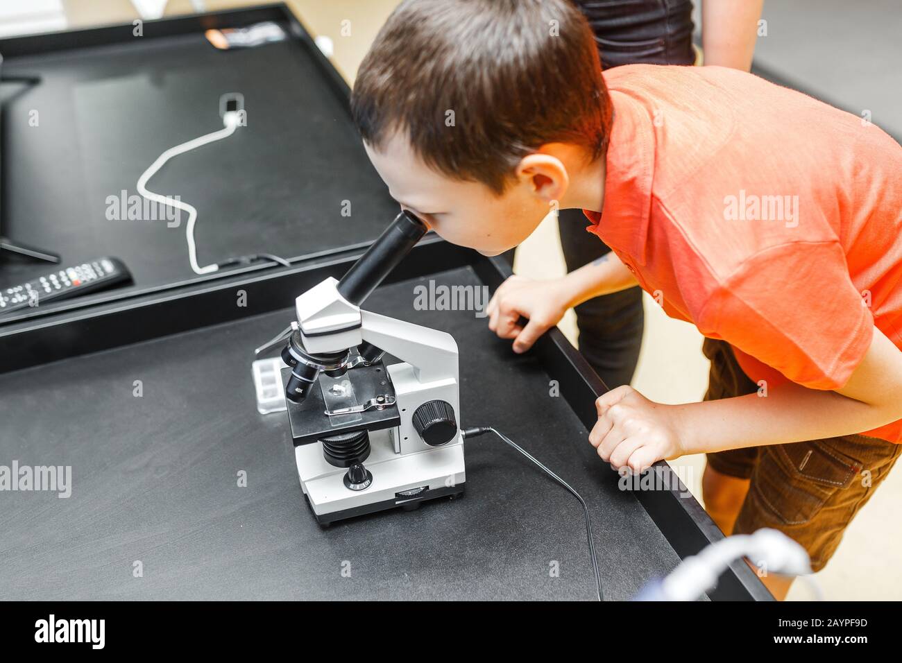 Boy in science class with electronic microscope, education concept Stock Photo
