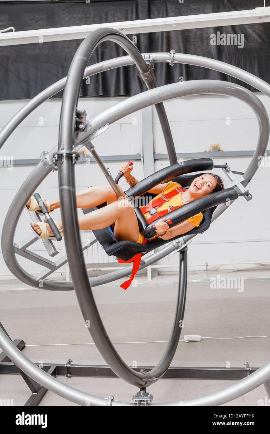 Woman having fun at the astronaut training gyroscope swing Stock Photo