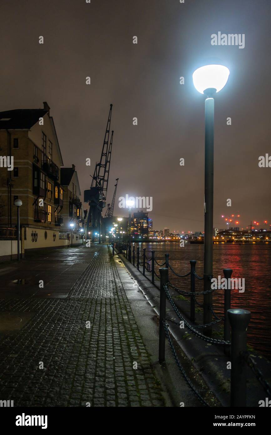 A view along the dockside at night at The Royal Victoria Docks in ...