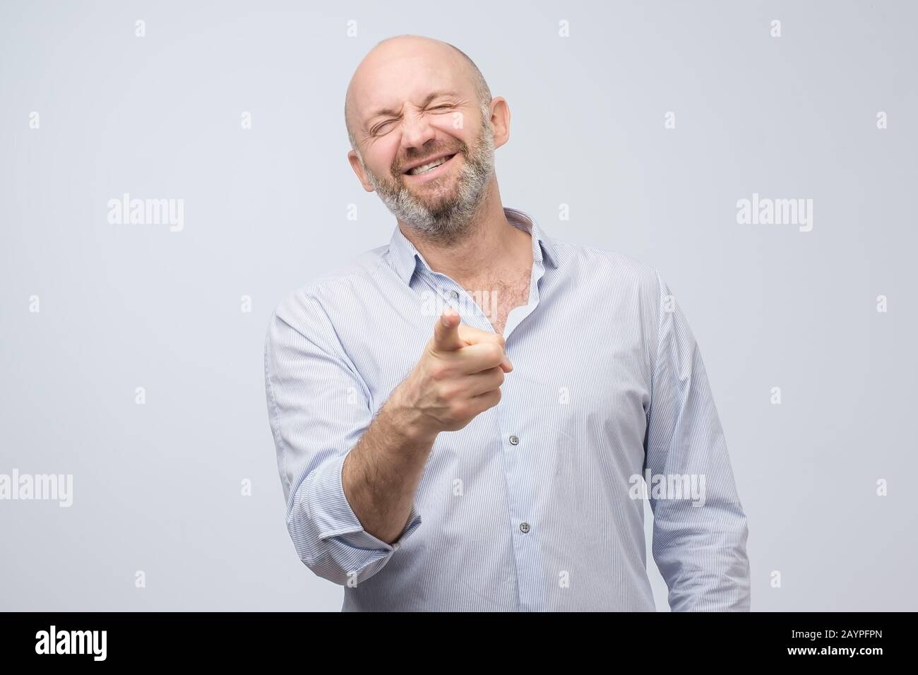 Mature laughing handsome excited, happy man pointing at you camera gesture with finger, isolated on white background. Positive emotion facial expressi Stock Photo