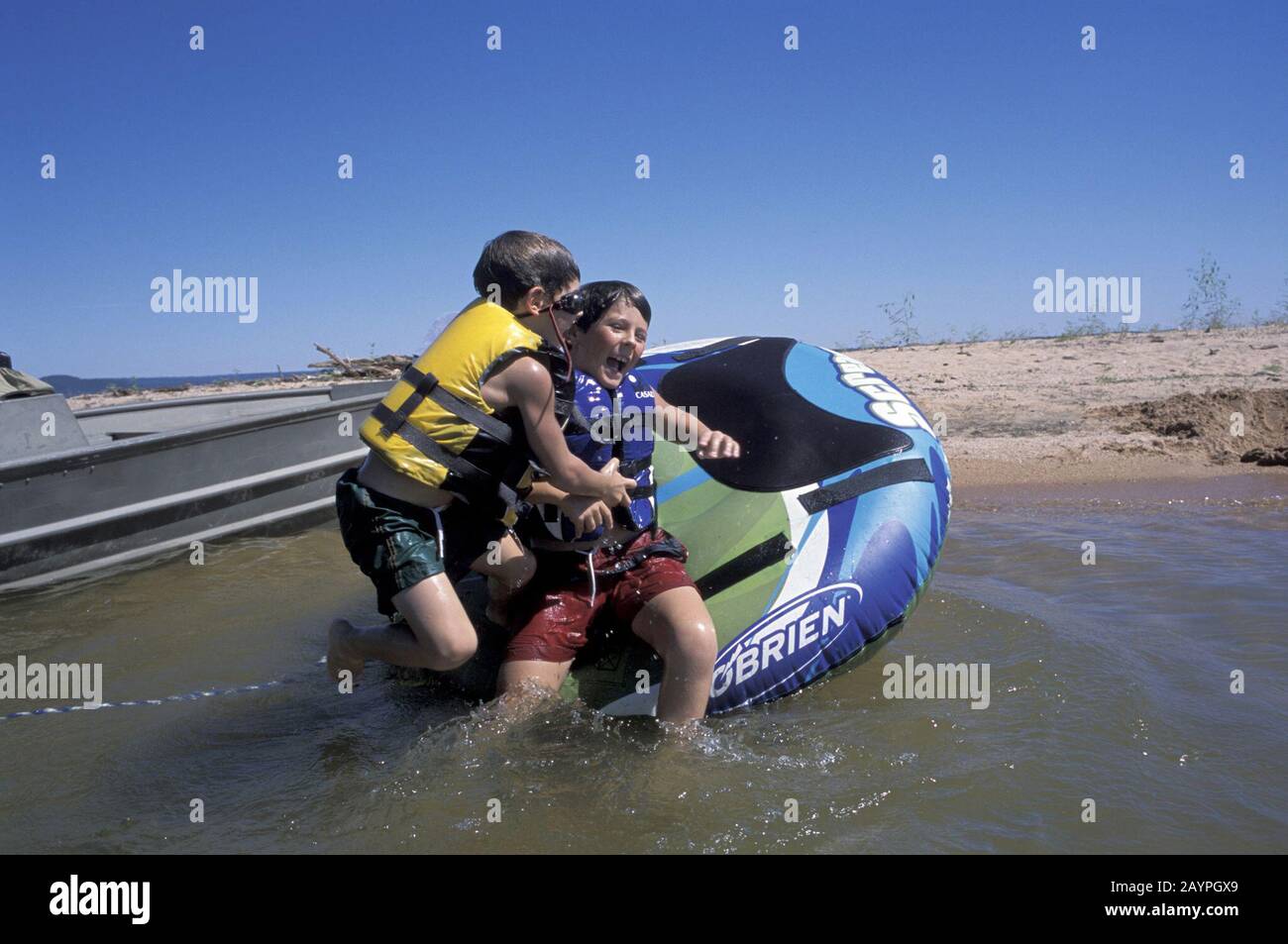 Lake Buchanan, Texas: Five and eight year old brothers play on tube at Lake Buchanan in central Texas. ©Bob Daemmrich Stock Photo