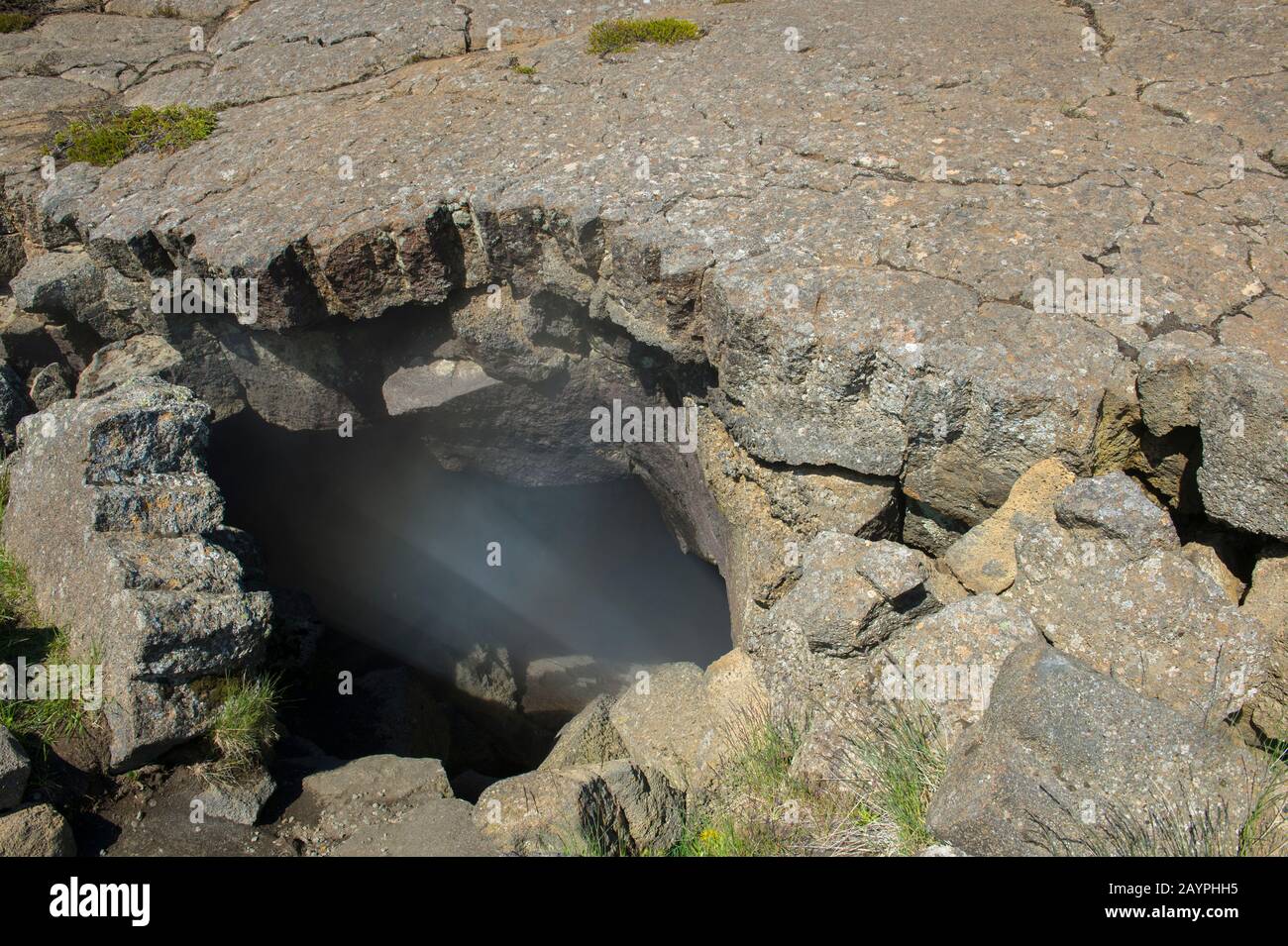 Steam rising from Grjotagja, a small lava cave near Lake Myvatn with a thermal spring inside in Northeast Iceland. Stock Photo