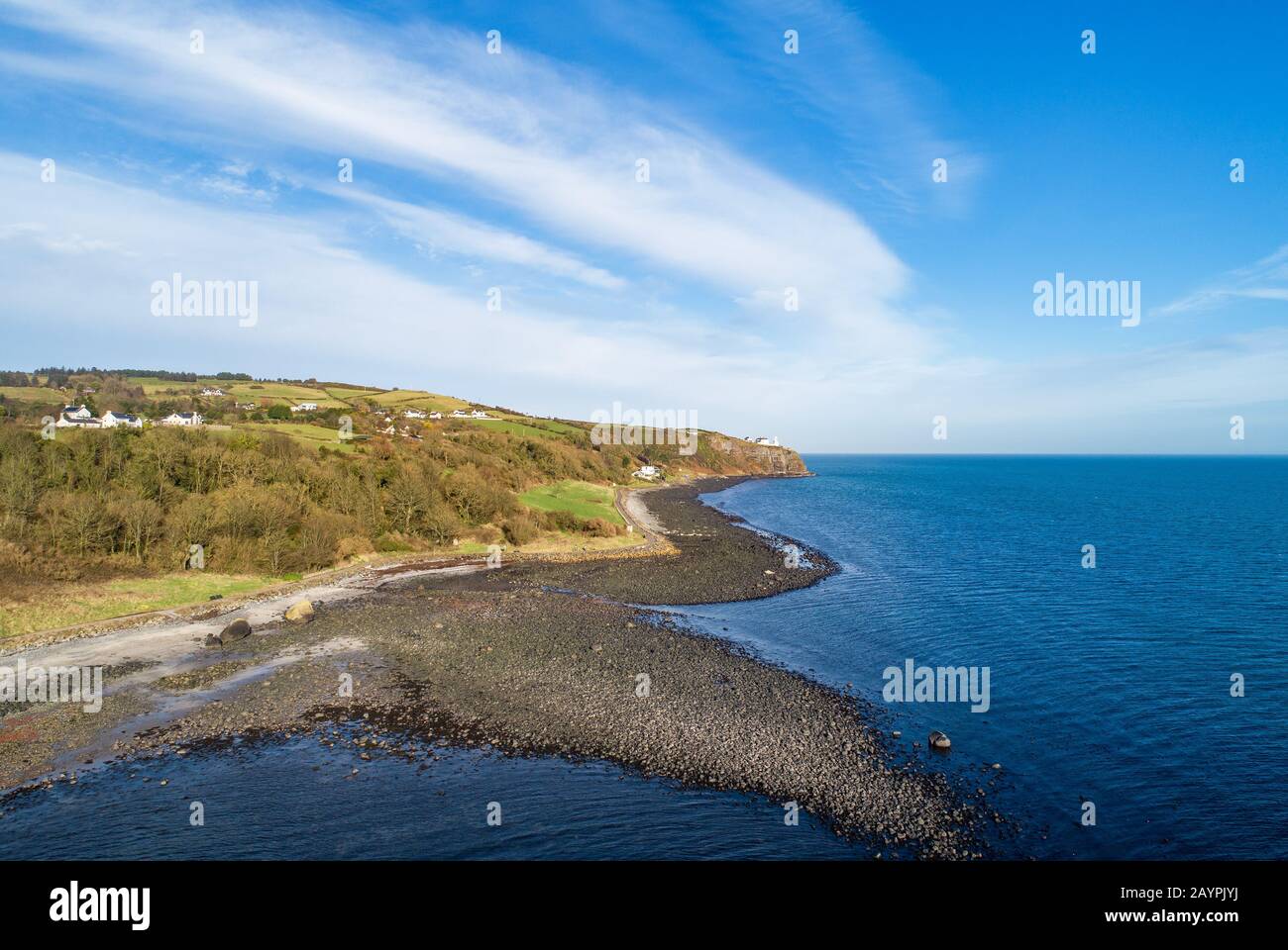 Atlantic coast at the entrance to the Belfast Laugh in County Antrim, Northern Ireland. Far view of Blackhead Lighthouse on a steep cliff. Aerial view Stock Photo