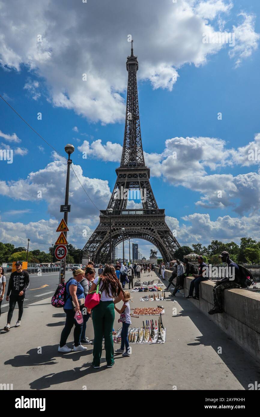 Tourists souvenirs street sellers & Eiffel Tower in Paris, France, Europe Stock Photo