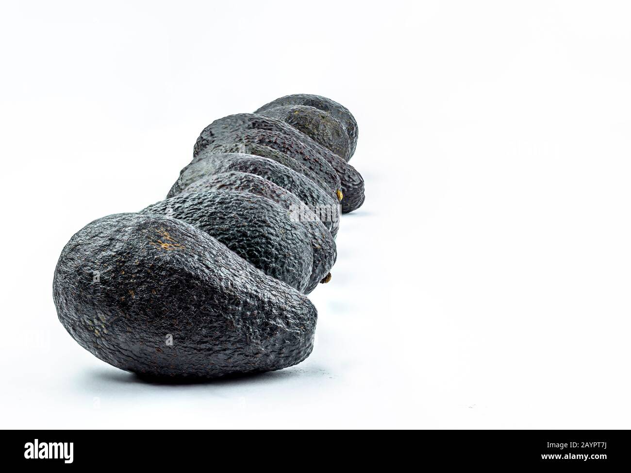 Many avocados in a row on white background Stock Photo - Alamy