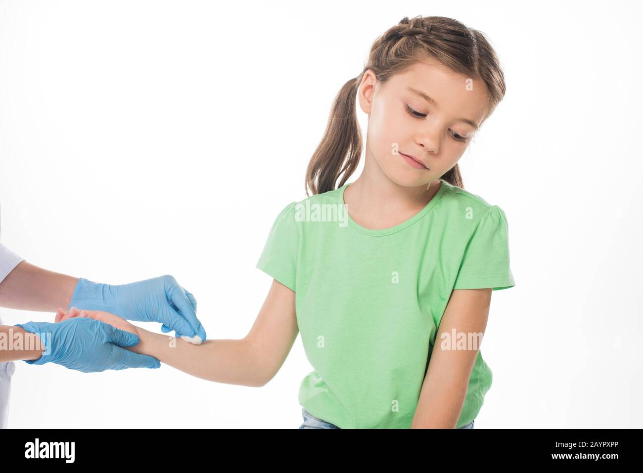 Pediatrician with cotton wool rubbing hand of kid isolated on white