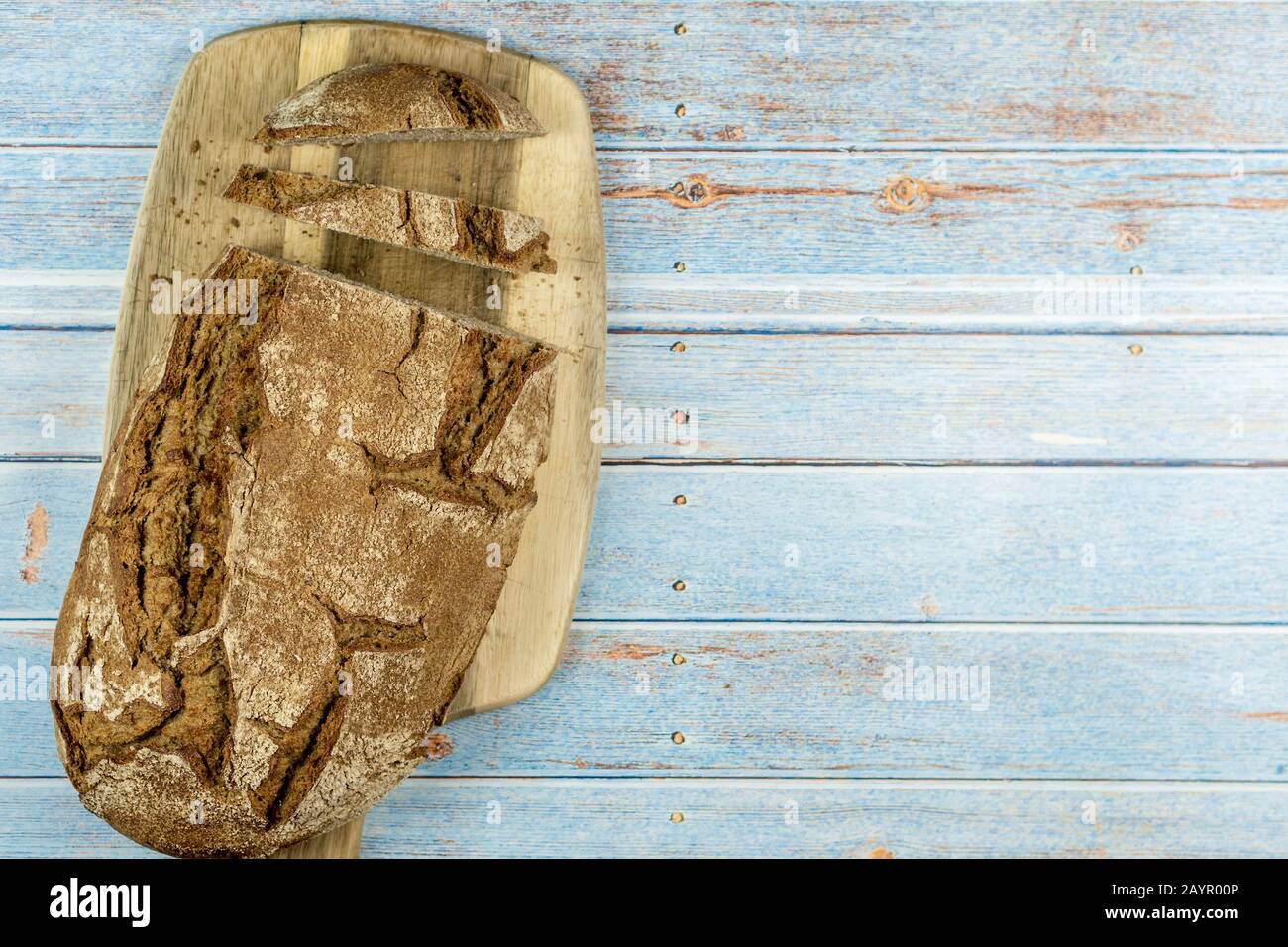 top view of homemade crusty rustical bread on blue wooden background Stock Photo
