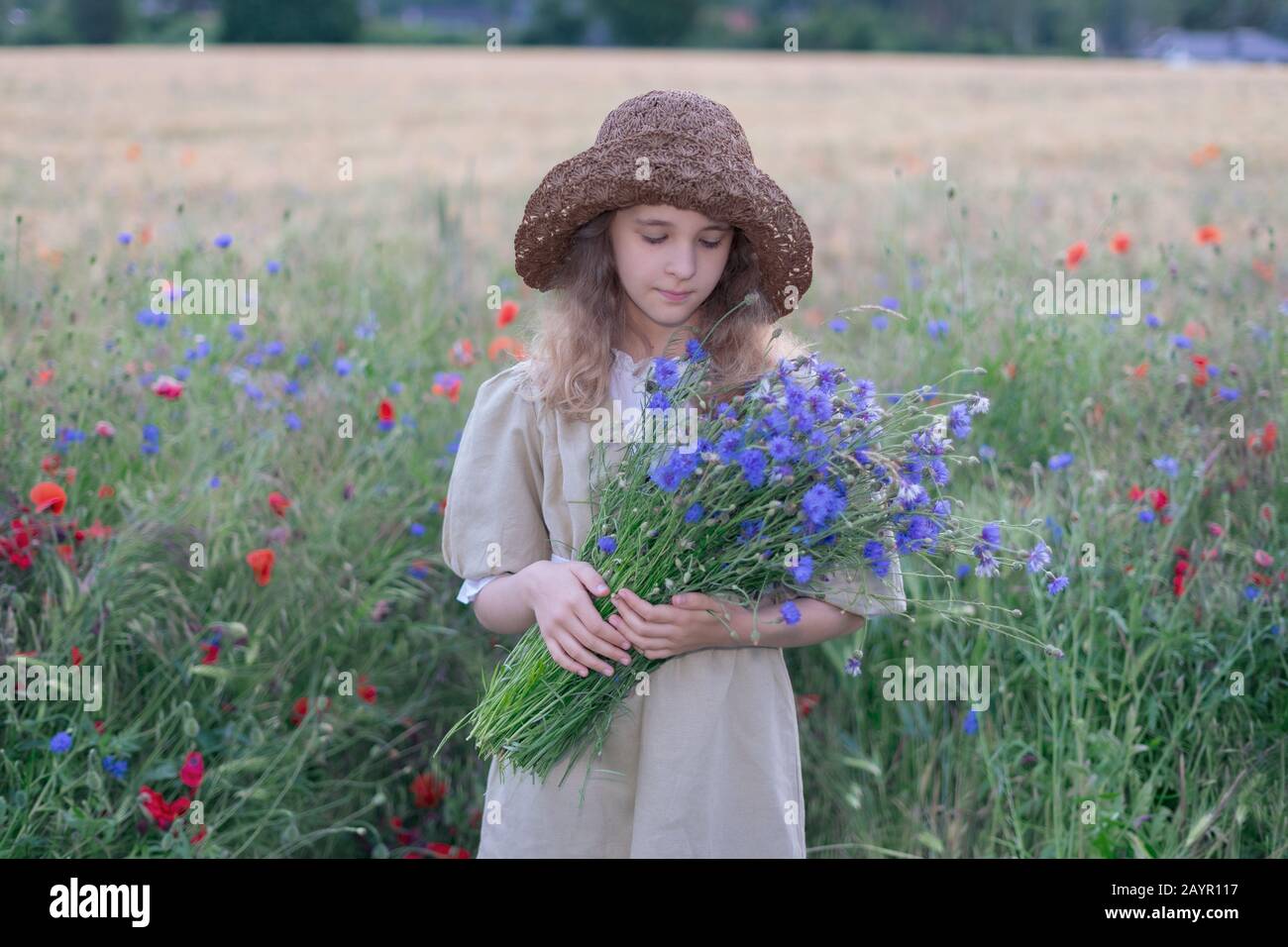 Portrait of a young girl in a hat with wildflowers in a basket Stock ...