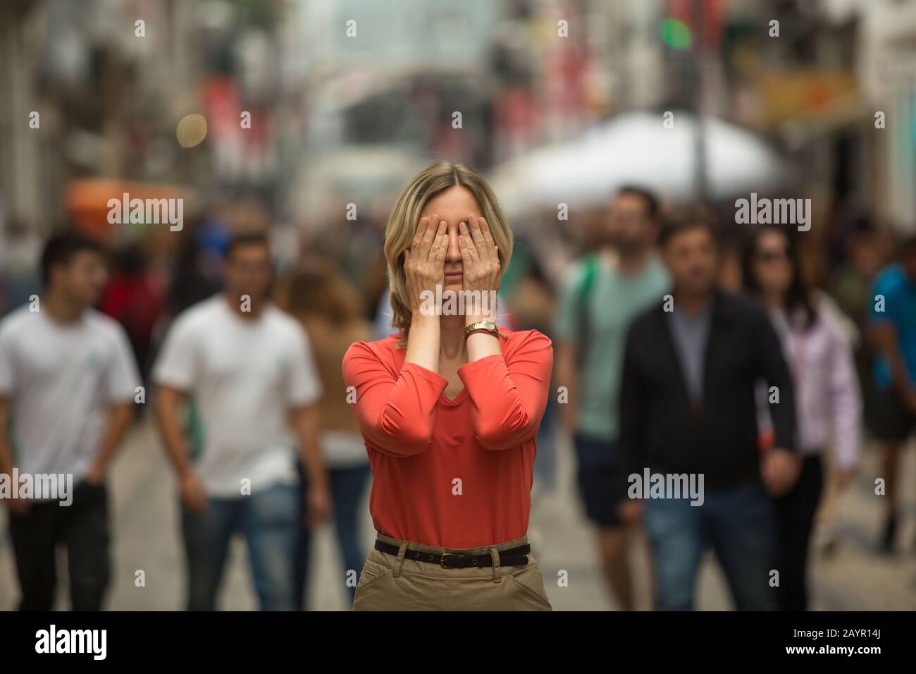 Panic attack in public place - woman covers his eyes. Stock Photo