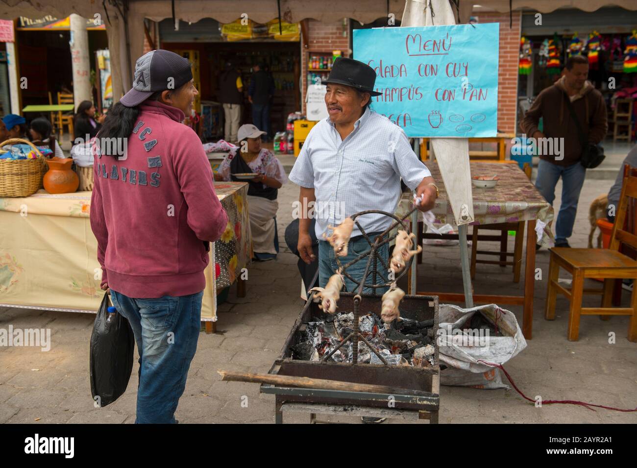 Street scene with a man barbequing guinea pigs in a small village near