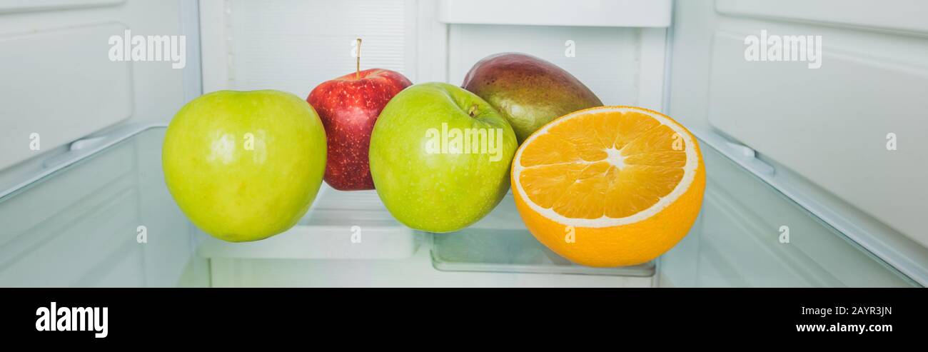 Panoramic shot of fresh mango with apples and orange slice on refrigerator shelf ,stock image Stock Photo