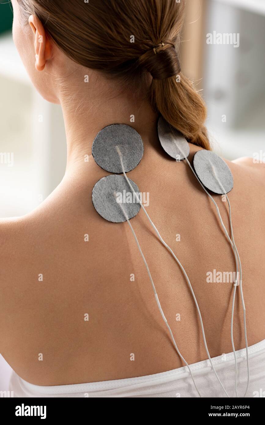 Back view of electrodes of neck of young woman during electrode