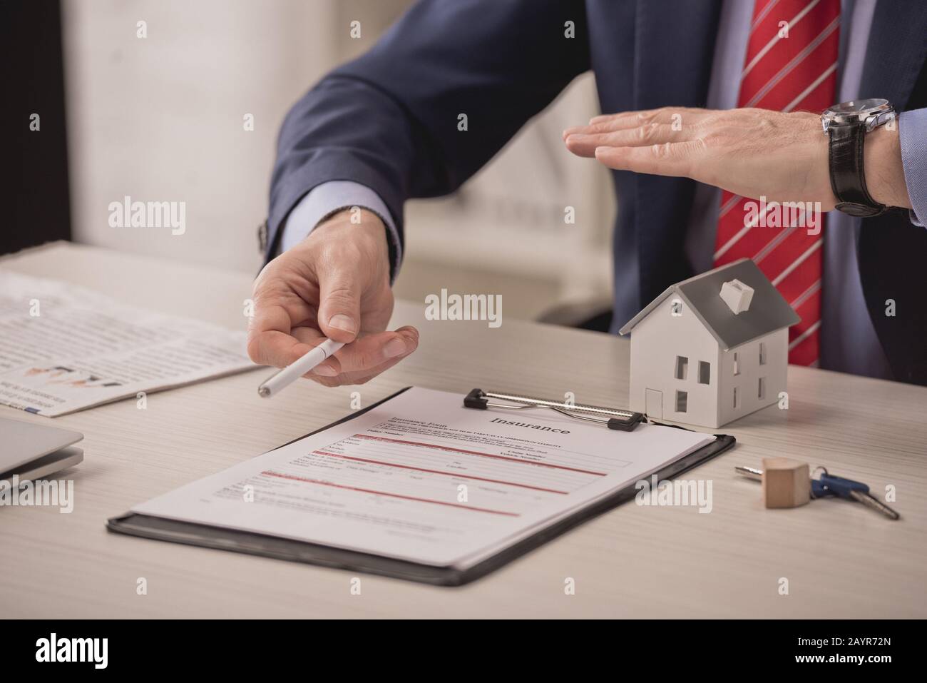 Agent View Lettering cropped view of agent holding hand above carton house model and ...