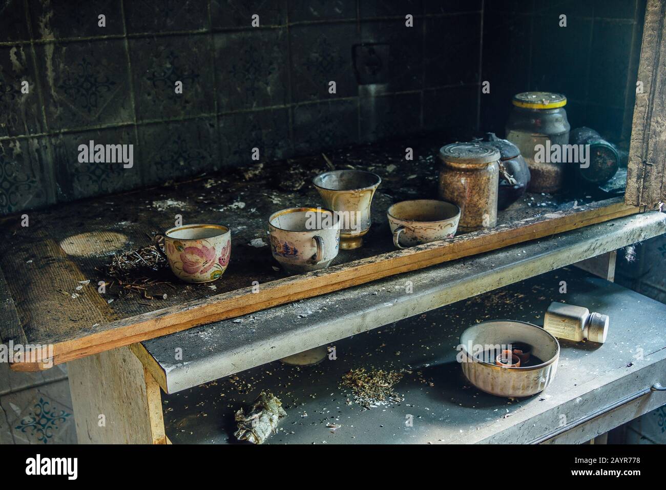 Burnt room interior. Burnt still life. Charred wall, cups in black soot Stock Photo