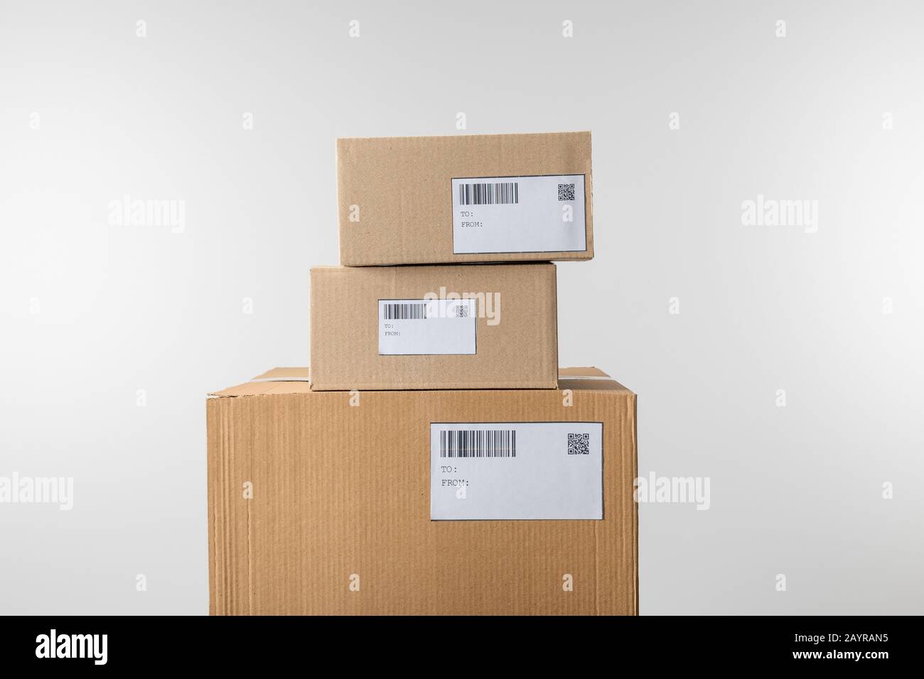 Stacked cardboard boxes with barcodes and qr codes on cards isolated on