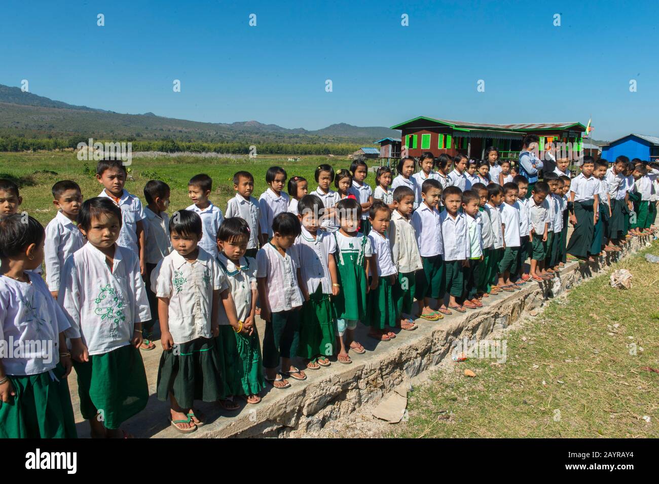 School children in school uniform performing a song for tourists at the