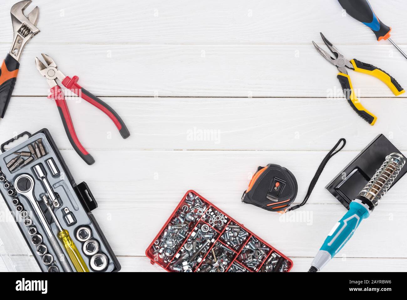 Top view of tools with soldering iron and pliers on white wooden background Stock Photo