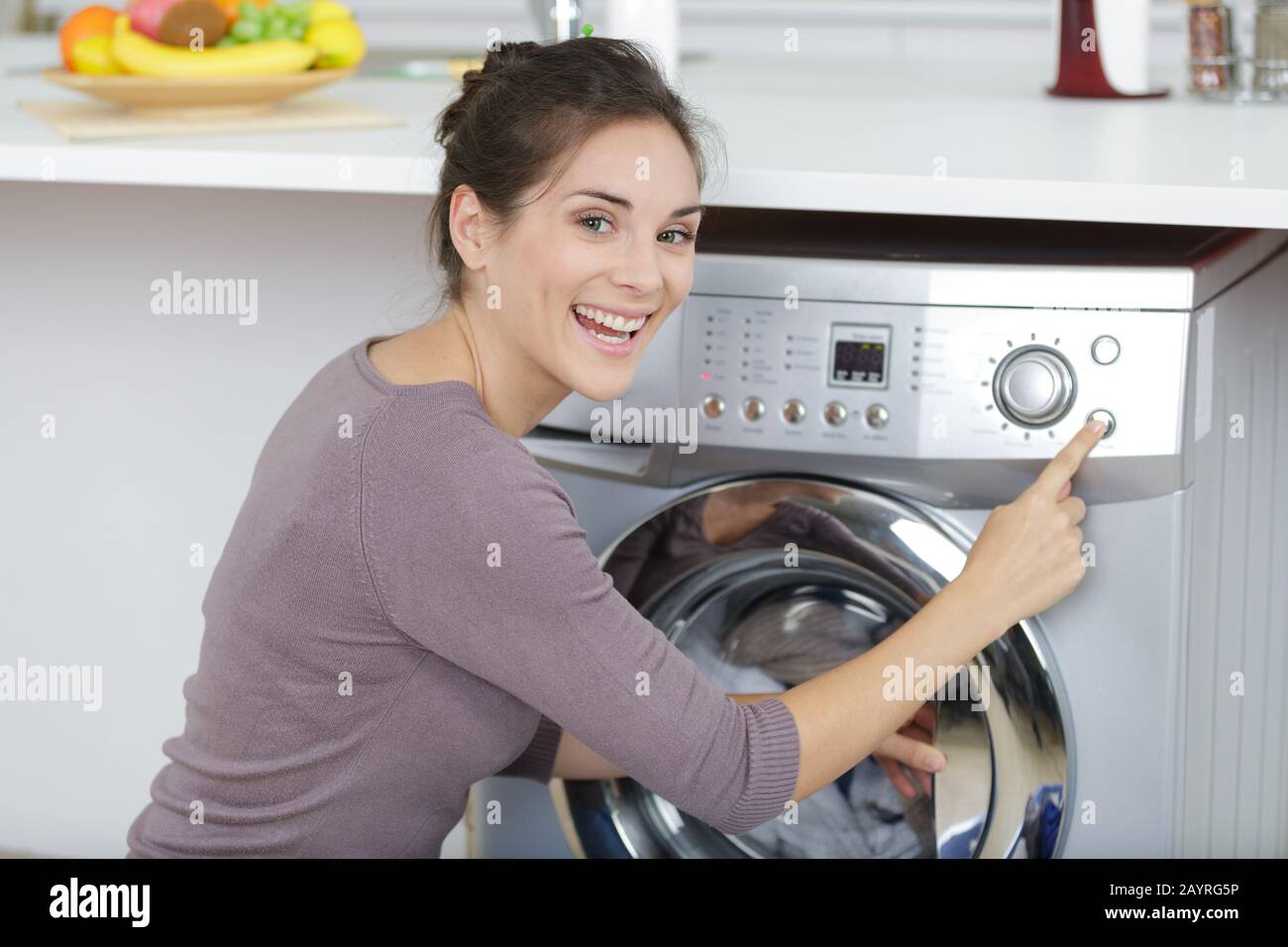 Woman Pressing Button To Start Washing Machine Stock Photo Alamy