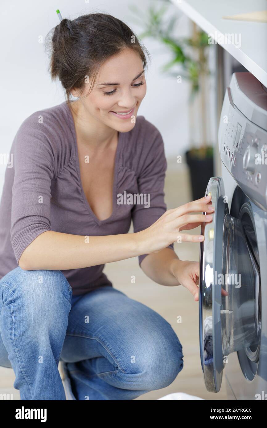 woman loading dirty clothes in washing machine Stock Photo Alamy