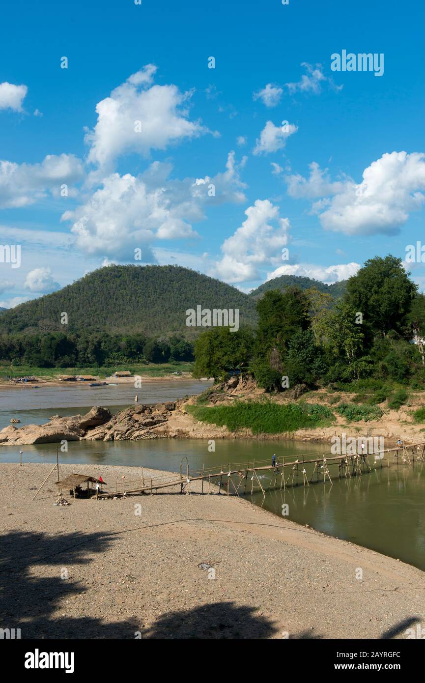 View of a bamboo bridge over the Nam Khan River at the confluence of the Nam Khan and Mekong Rivers at Luang Prabang in Central Laos. Stock Photo