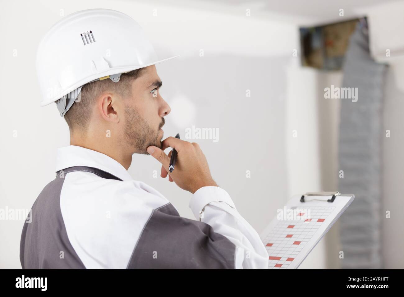smart pensive builder thinking about something indoors Stock Photo