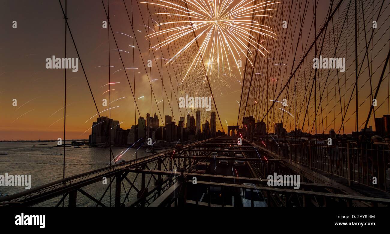 Festive fireworks on a brooklyn Bridge sunset with Manhattan skyline in