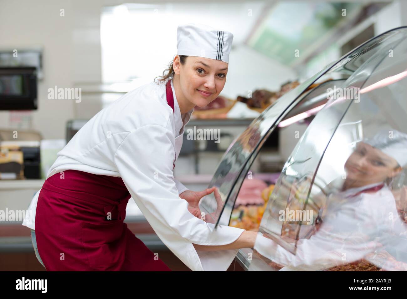 female butcher lifting cover on chiller Stock Photo - Alamy