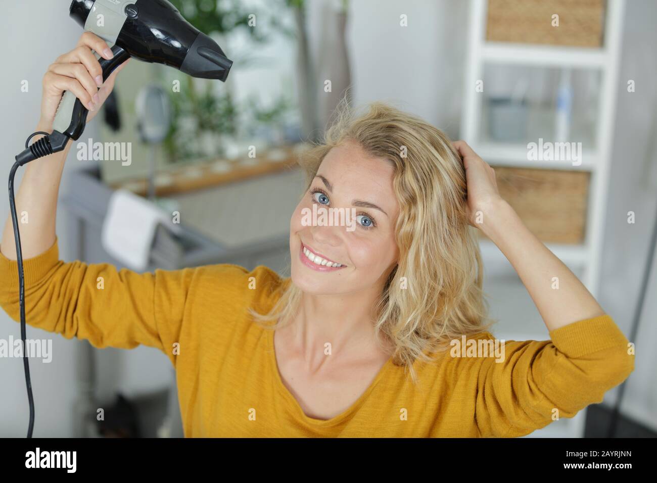 woman dries hair with a hairdryer Stock Photo - Alamy