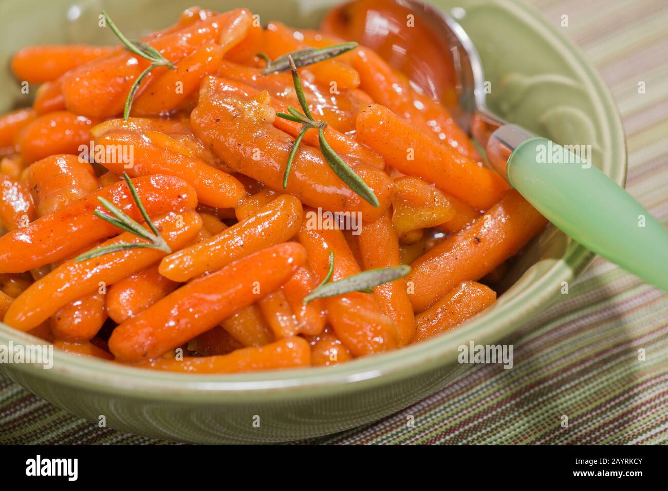 Bowl of marmalade glazed carrots with fresh rosemary on top Stock Photo