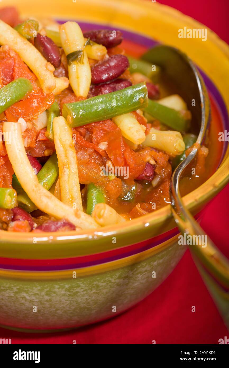 Herbed three-bean dish with tomatoes in a bowl, containing green beans, yellow wax beans and kidney beans Stock Photo