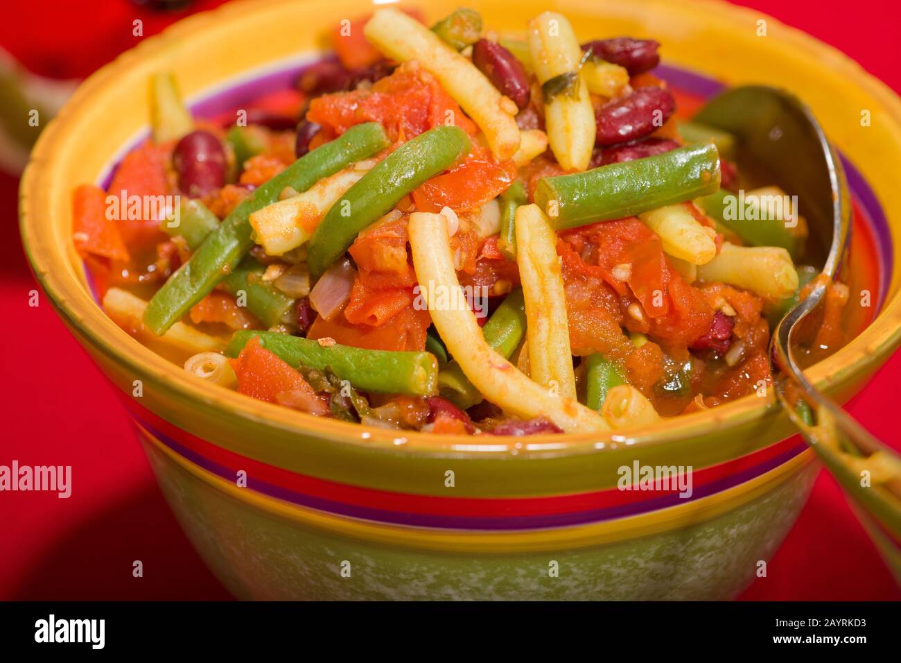 Herbed three-bean dish with tomatoes in a bowl, containing green beans, yellow wax beans and kidney beans Stock Photo