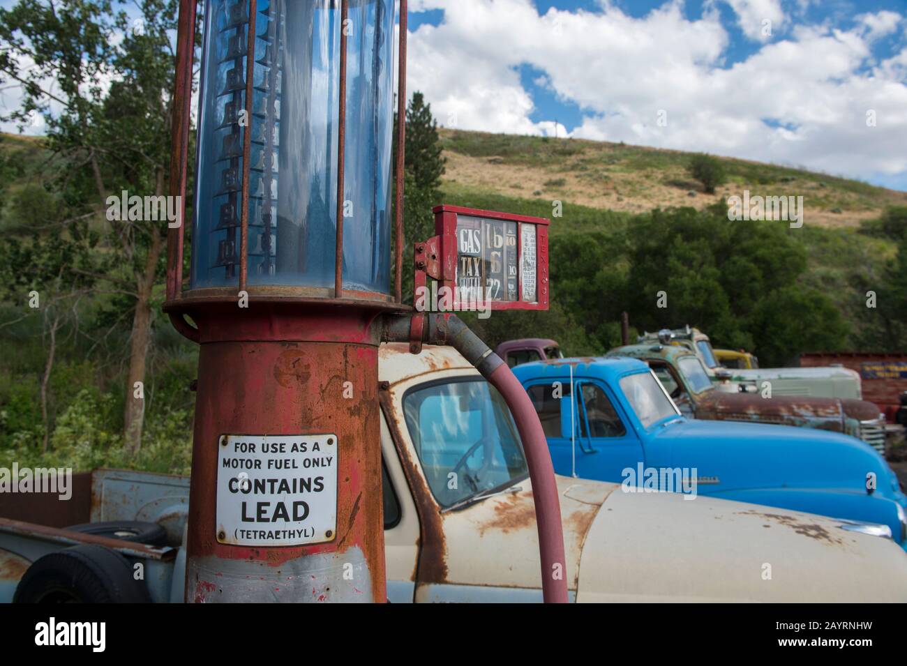 Antique gas pump and cars at an old gas station, part of an old car