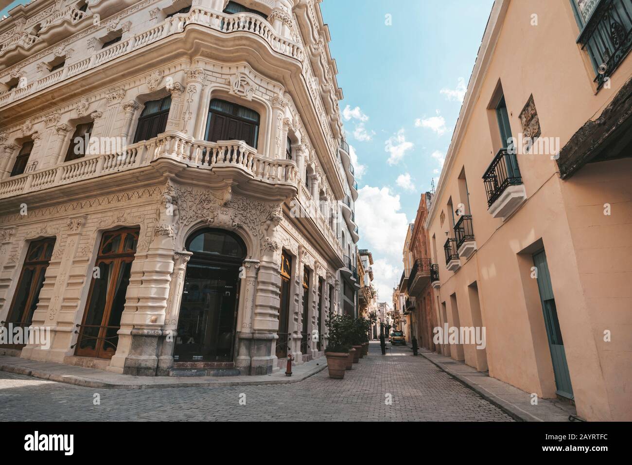 An alley in old Havana between a rich and a poor house. Beautiful facade of the building in the colonial style. Contrast of cheap and expensive housin Stock Photo