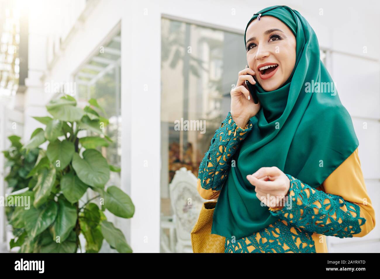 Happy beautiful young muslim woman in hijab walking outdoors and ...