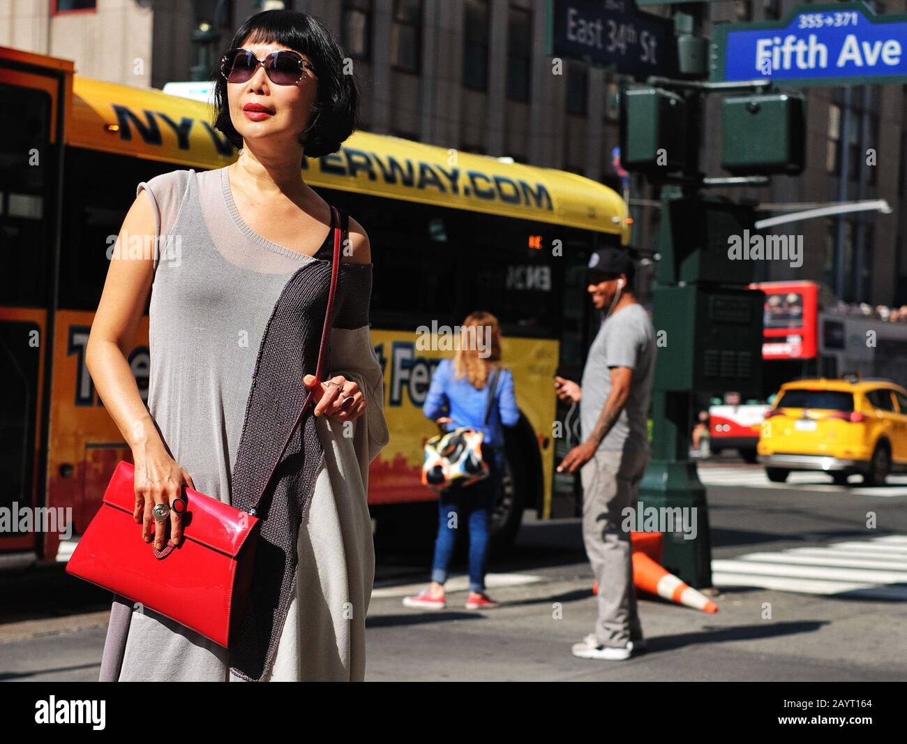 Asian woman standing in a multi colored street scene on 5th Avenue