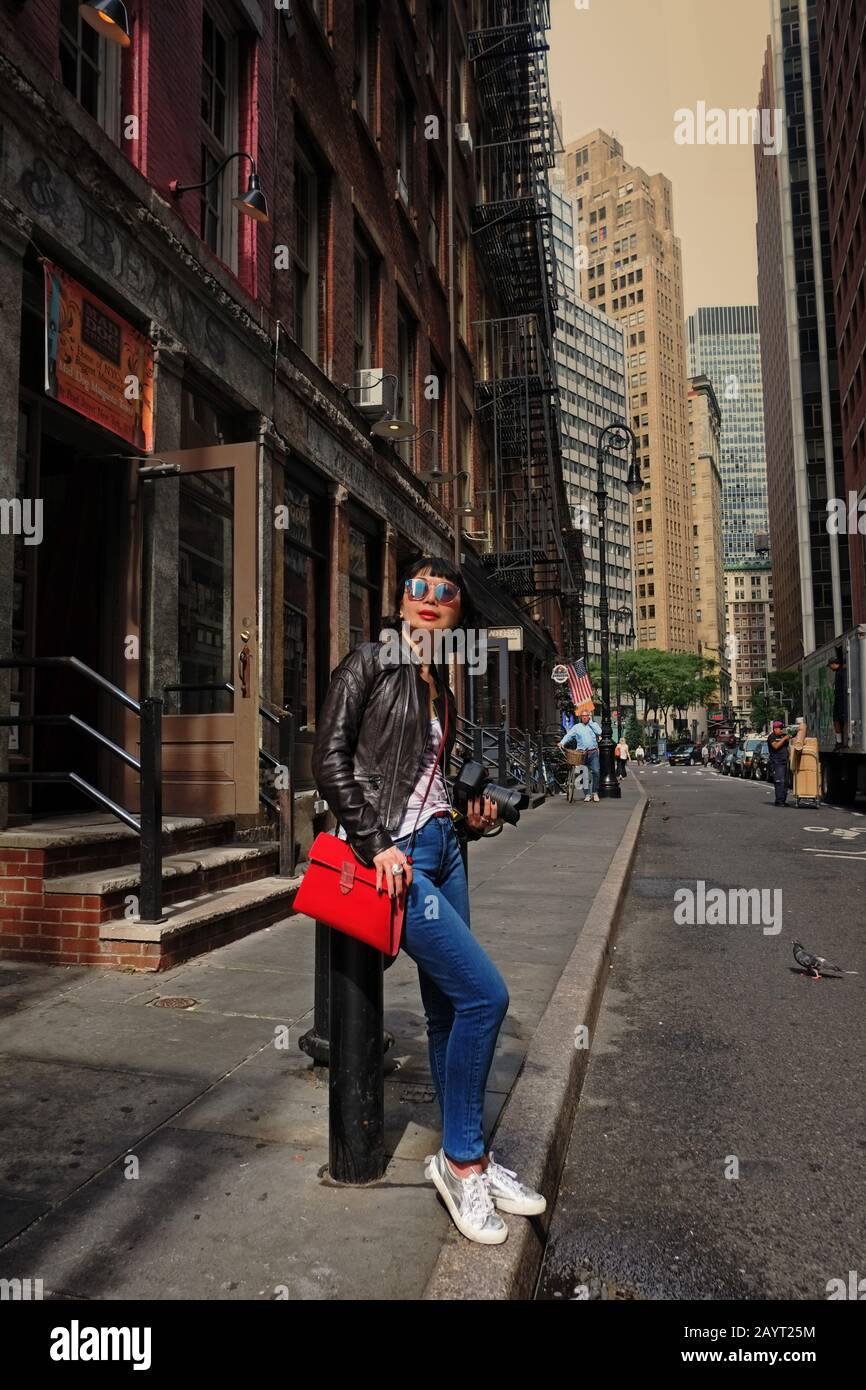 A stylish Asian woman tourist in a tenement lined old street of ...