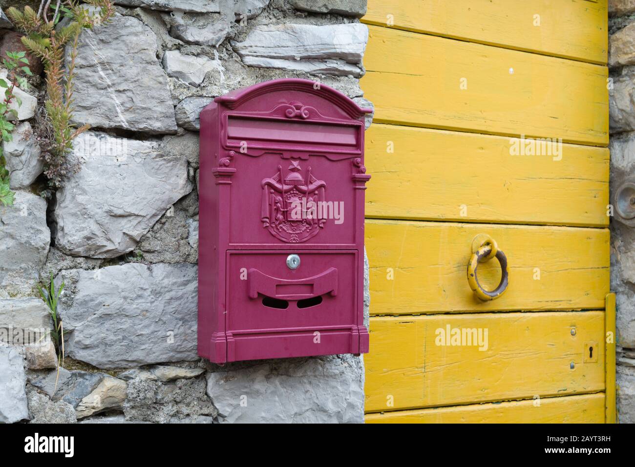 Vintage postbox on the stone wall near the door in the Italian town Porto Venere Stock Photo