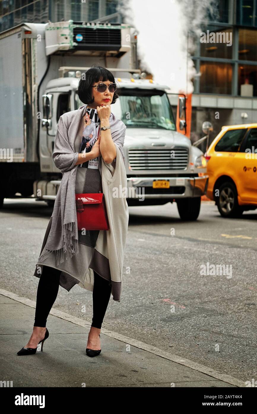 Lifestyle fashion in New York, a stylish asian woman in a grey dress, red  bag on Madison Avenue, traffic and street steam in background Stock Photo -  Alamy