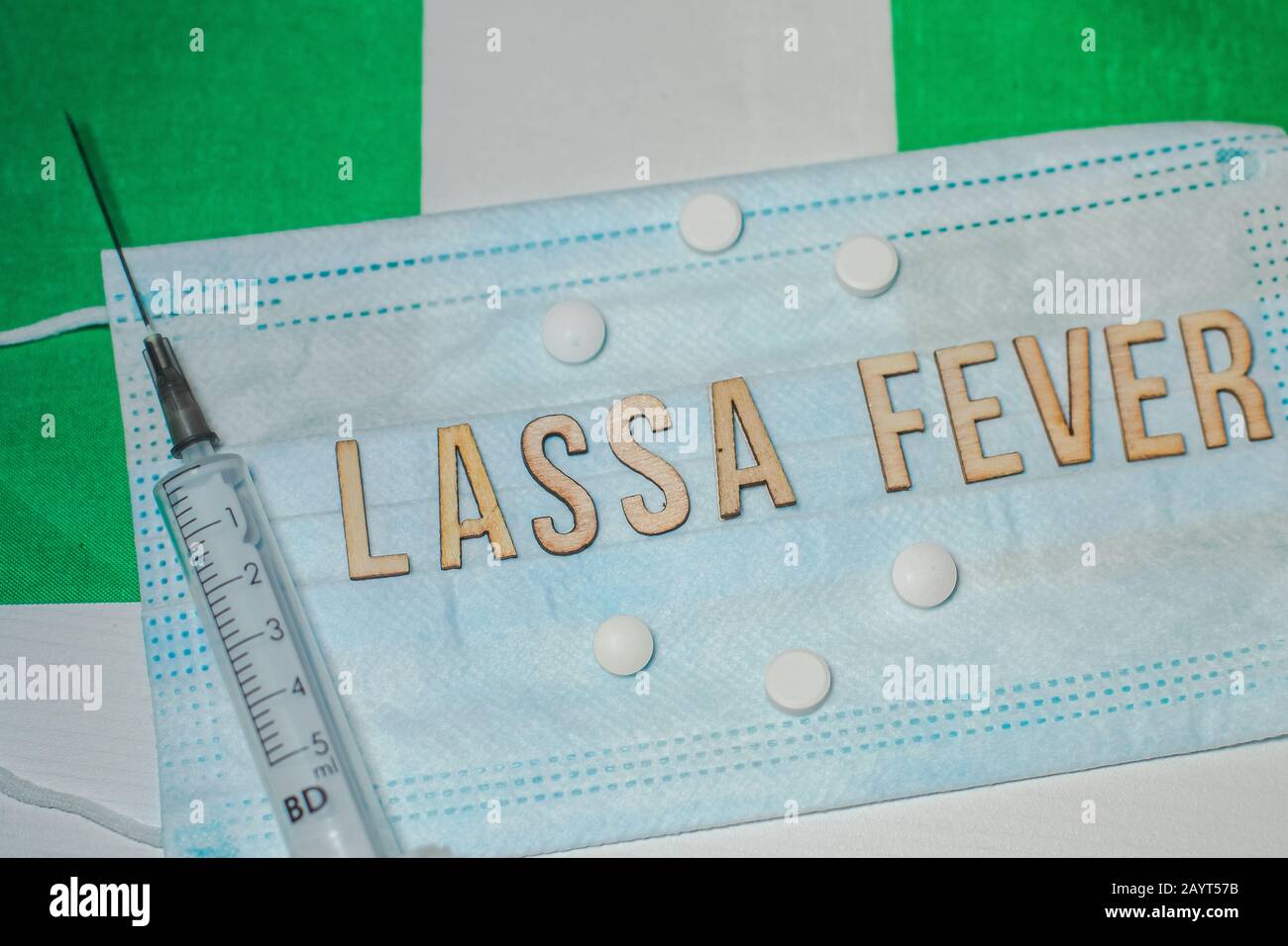 Nigerian flag under words Lassa fever outbreak concept. protective breathing mask and syringe. Lassa hemorrhagic fever LHF endemic in West Africa incl Stock Photo