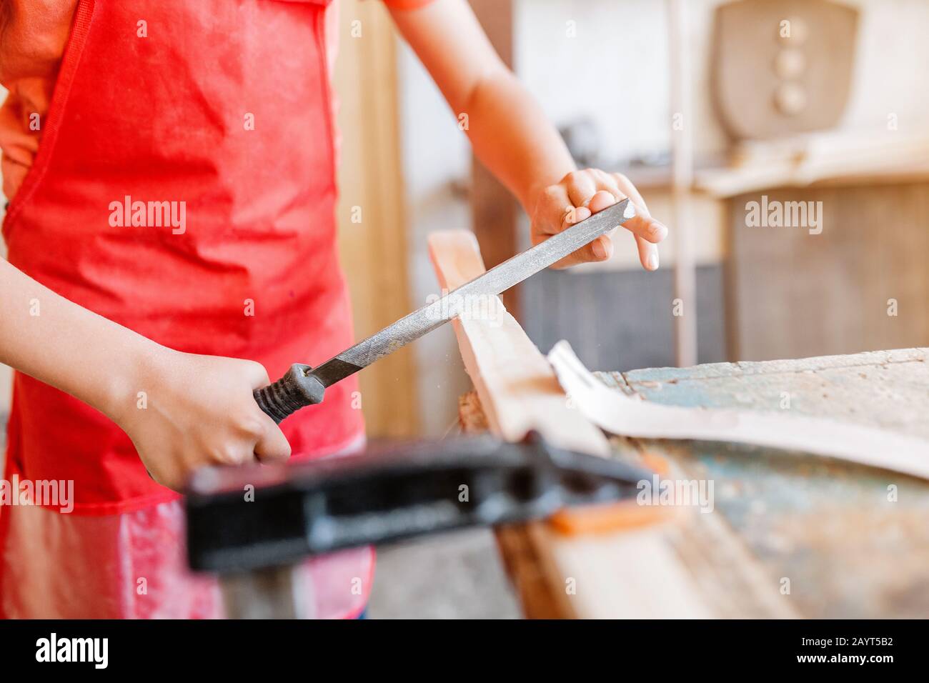 Little talented genius boy works with wood in a carpentry The