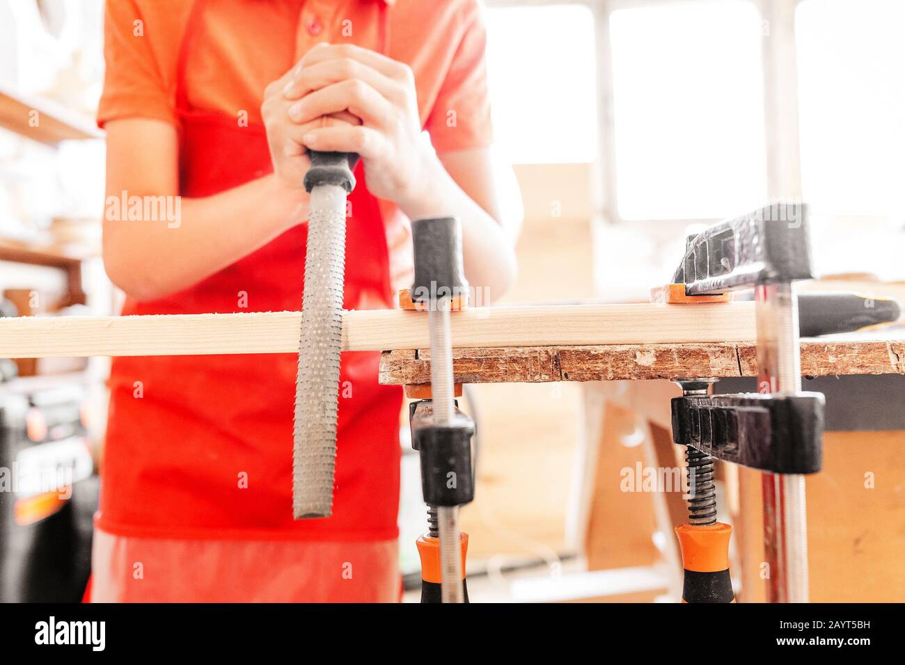 Little talented genius boy works with wood in a carpentry The
