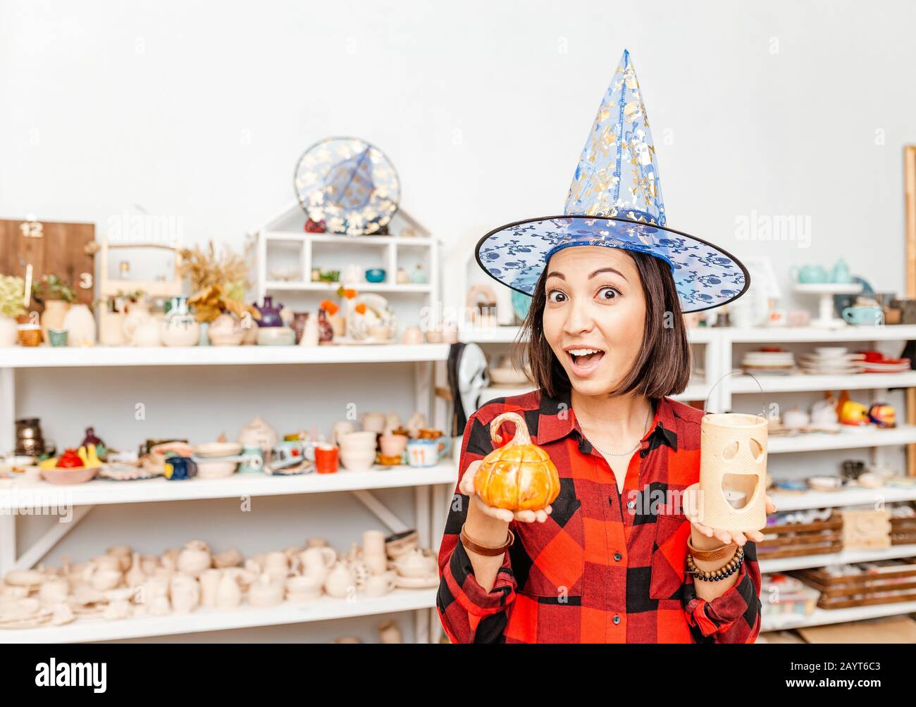 Beautiful magician woman in hat with halloween ceramics Stock Photo